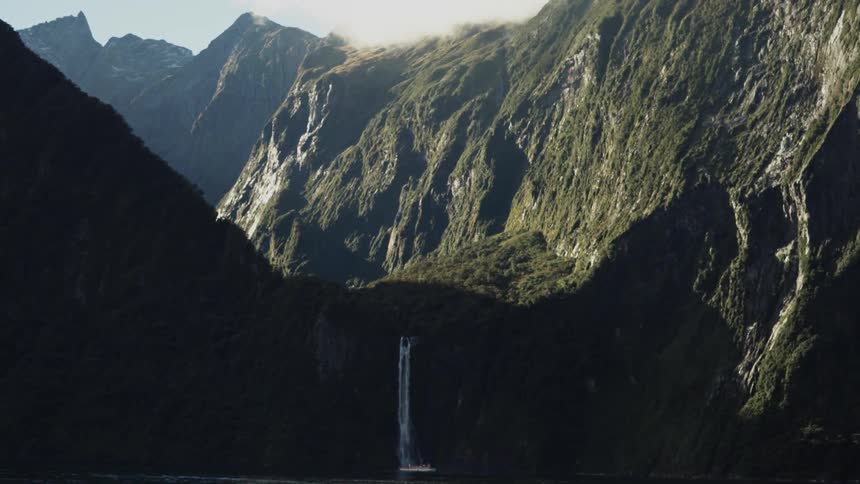A waterfall falls from a mountain during the day