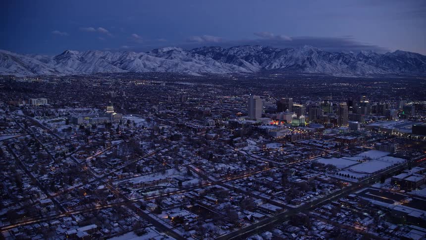Aerial view of a metropolis with snow and mountains on the horizon