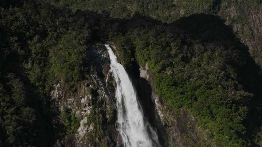 A waterfall pours off the mountain