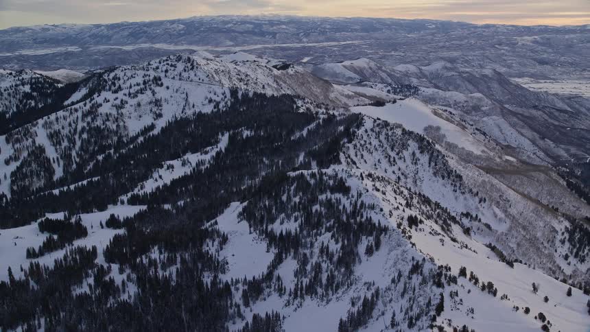 Panorama of a mountain range covered in snow on a cloudy day