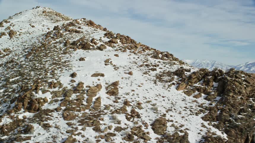 Aerial of a rocky mountain range with ice and snow during winter
