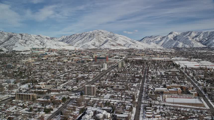 The town is covered in snow by the mountains