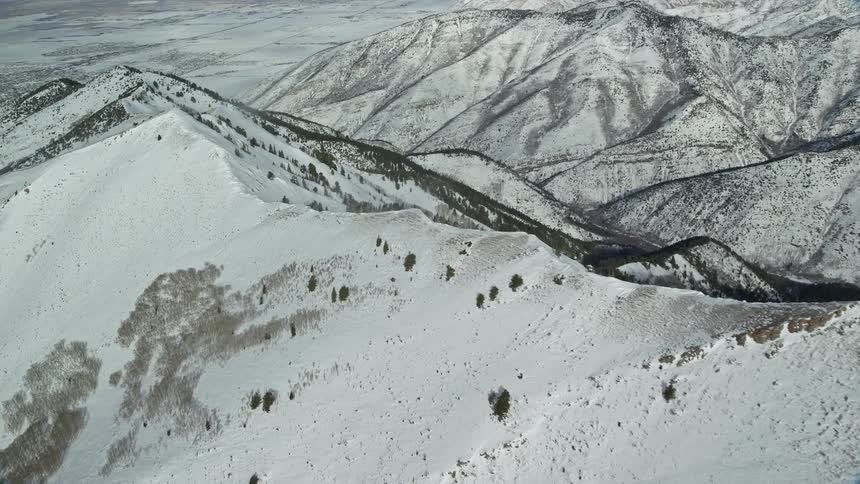 Aerial panorama of snowcovered mountains and peaks in daylight