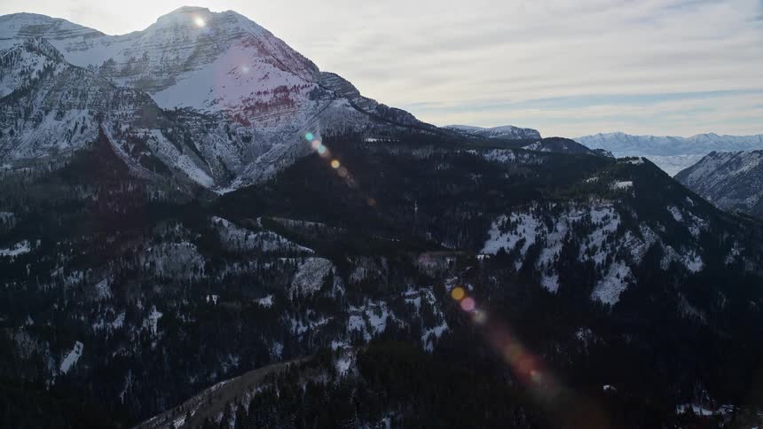 Aerial of valley with forest and mountains with snow during winter