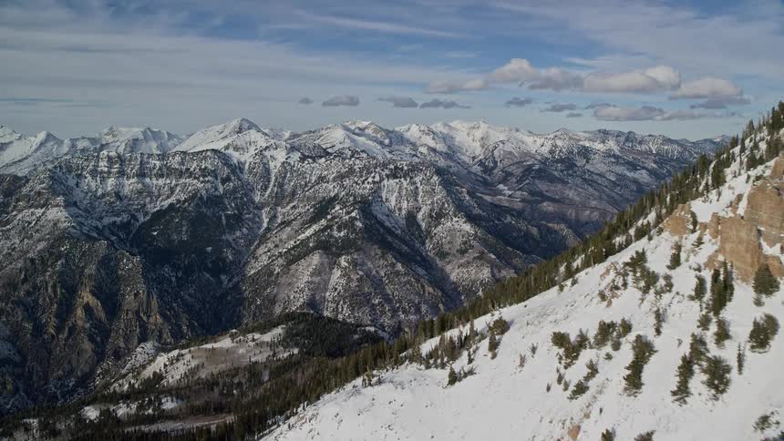 Aerial of a rocky mountain range covered in snow during winter