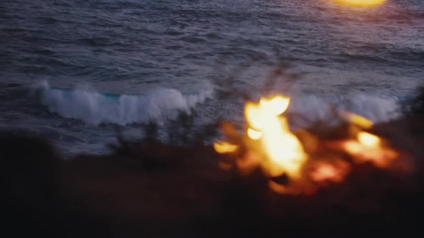 A campfire is on the beach