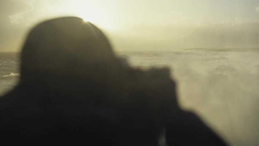 A person photographing the furious waves of the sea during the early hours of the morning