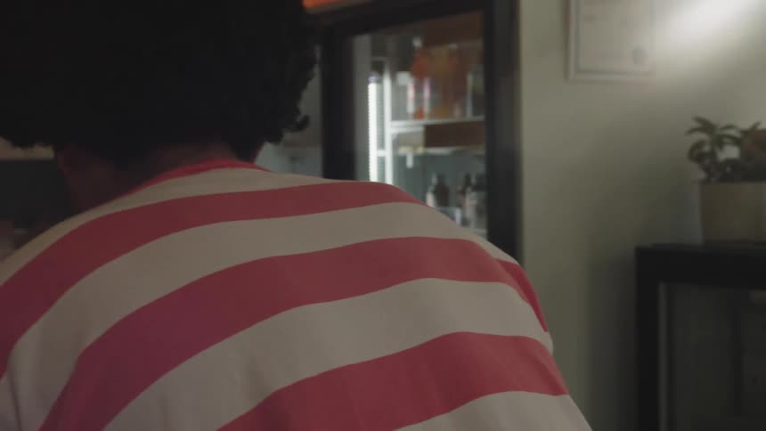 Portrait of a man setting up a table inside an establishment