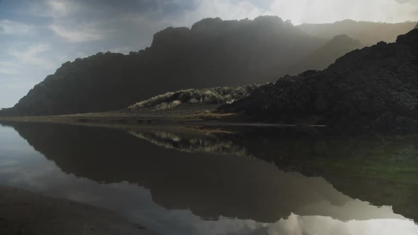 A landscape of water reflecting mountains of rocks