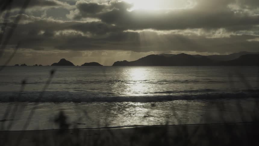 Mountains in the background as a backdrop to a beach during sunset