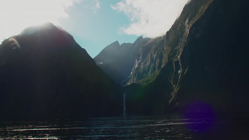 View of mountains with a waterfall cascading into a river
