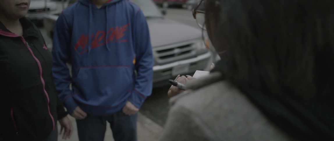 A woman signs a photograph in front of people