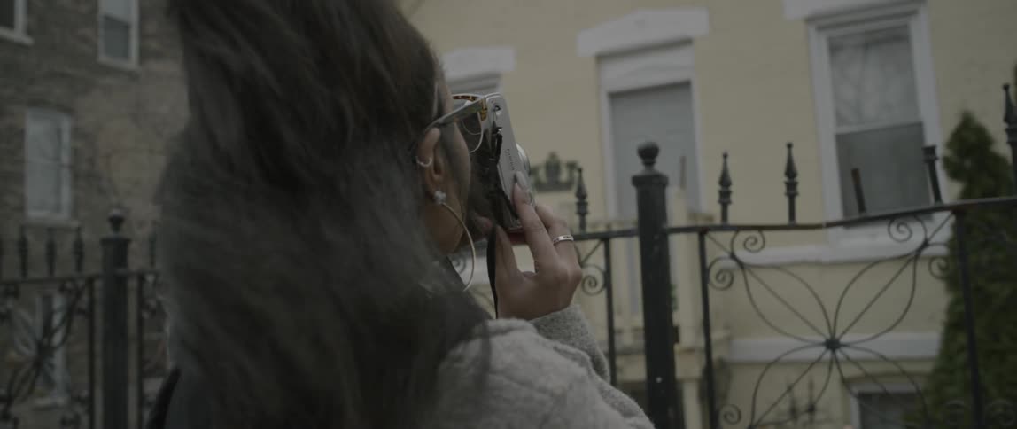 A woman takes a photo of a home