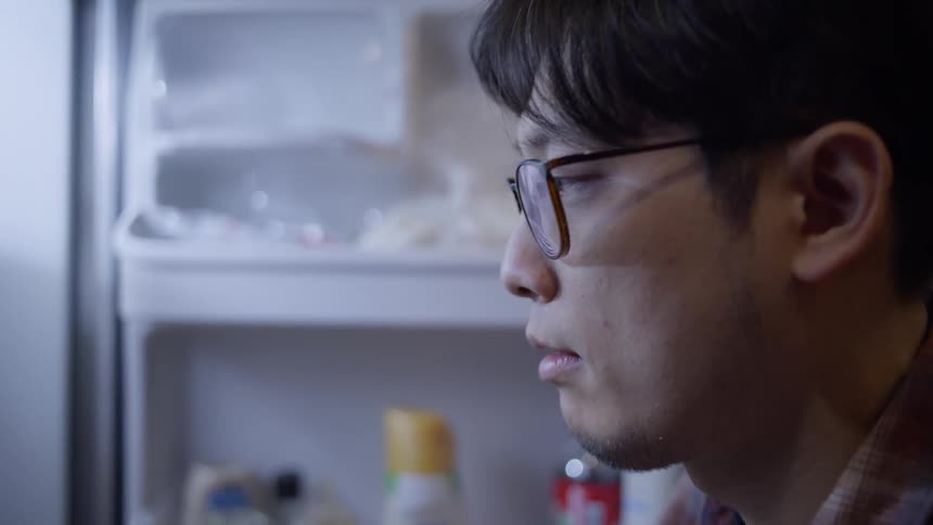 A thoughtful man choosing ingredients in the refrigerator