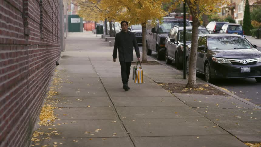 A man walking through his neighborhood on a cold day