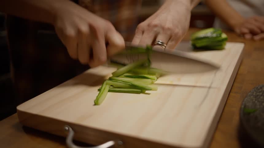 Person cutting vegetables on a cutting board on the counter top