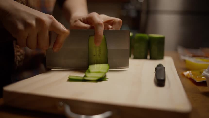 A person is slicing cucumbers
