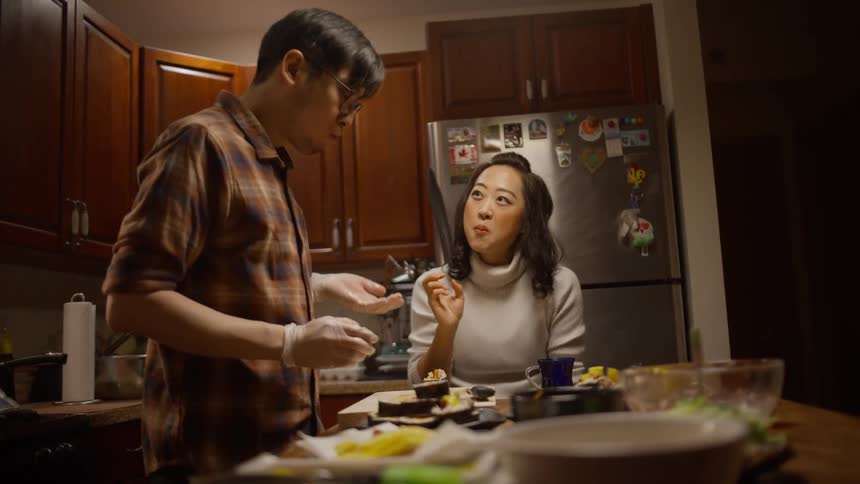 Couple cooking and taste testing Korean food together