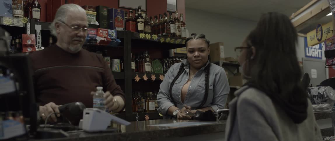 A woman goes to the counter to buy water