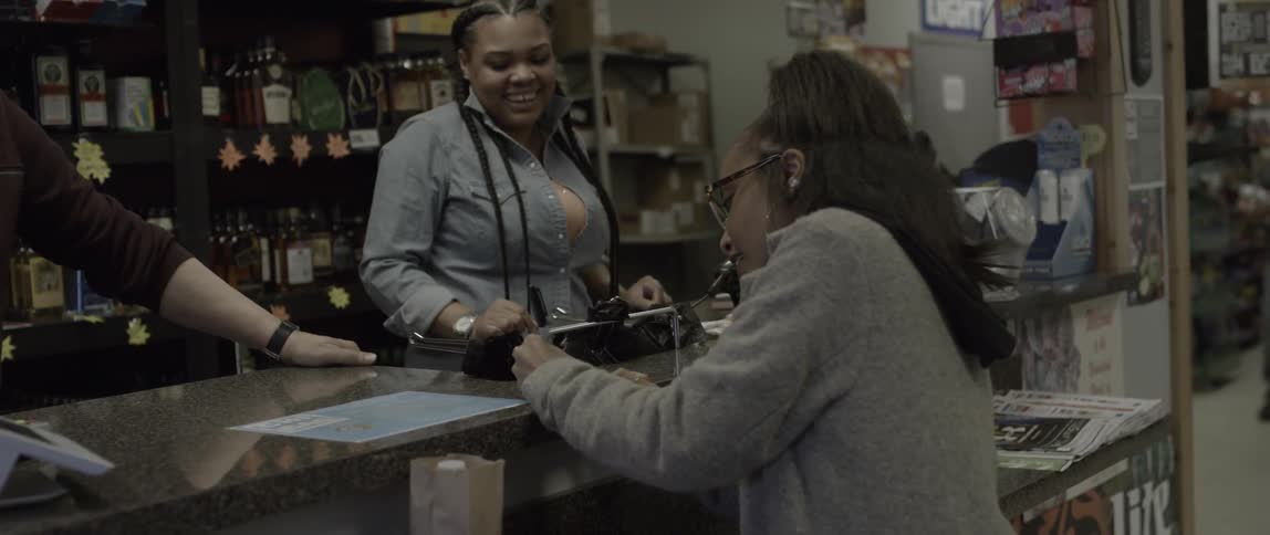 A woman writes on a counter in a store