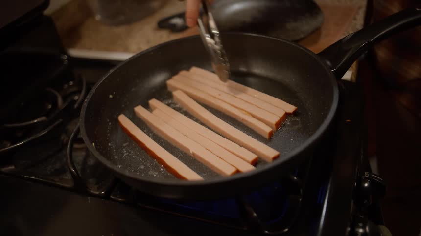 Closeup of a frying pan with a protein being fried