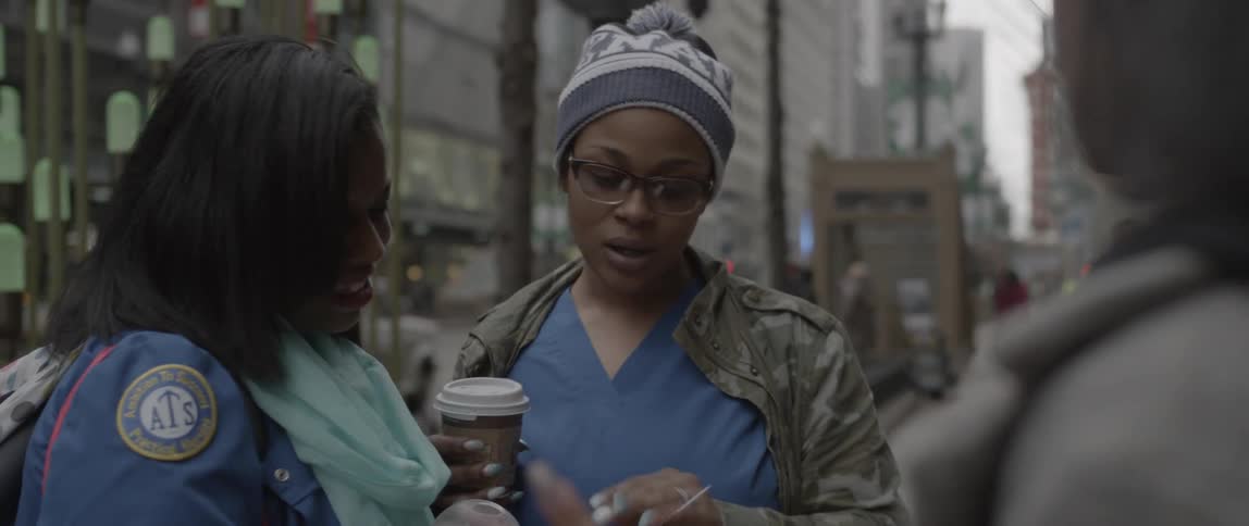 Women talk on a busy street sidewalk