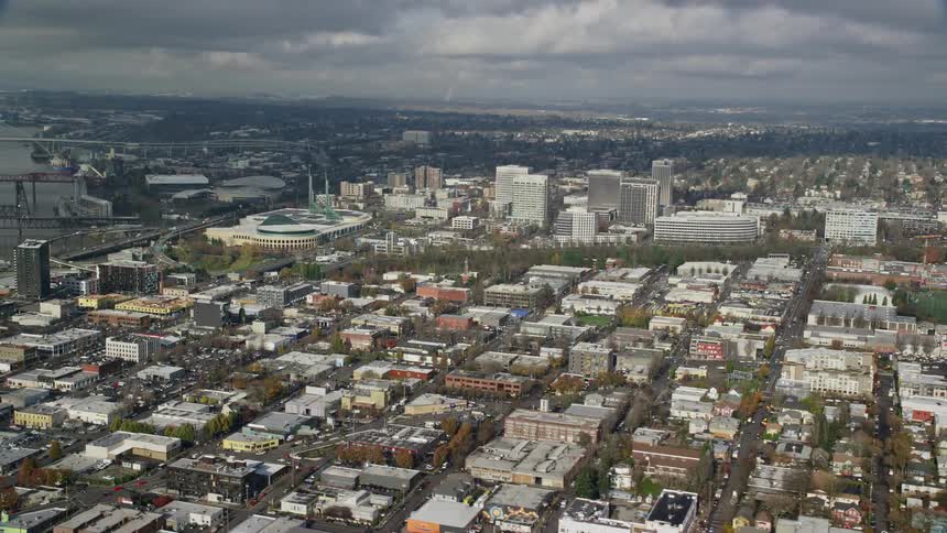 Aerial view of a mediumsized city with numerous houses and some buildings on a cloudy day