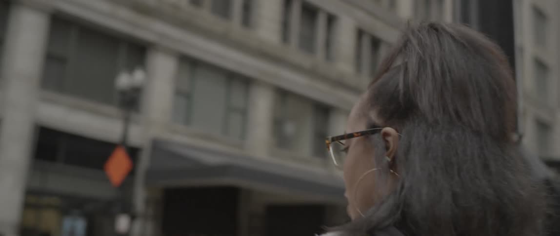 A woman walks to the corner in the city