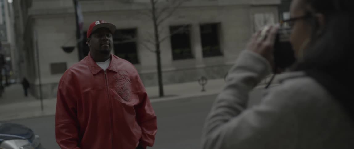 A woman talks with a man and takes his photograph