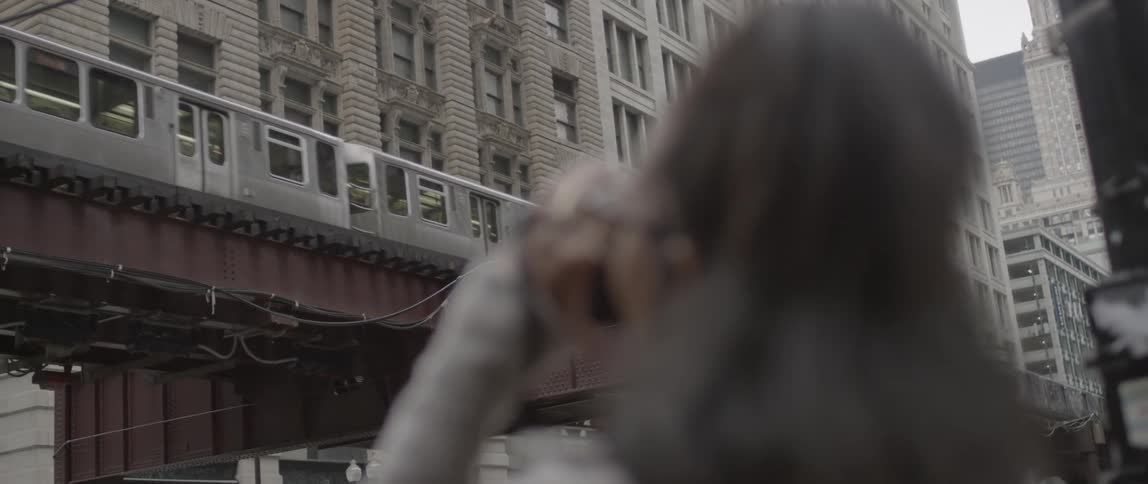 A woman takes a photograph of a train passing by
