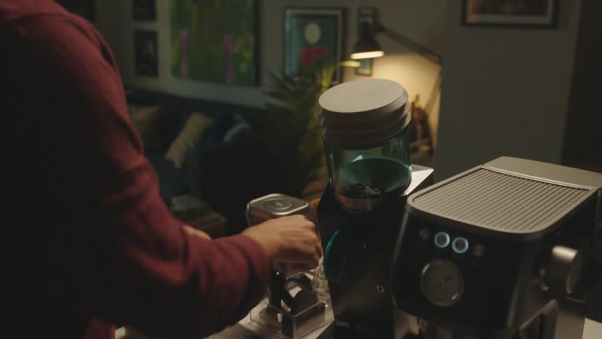 Man indoors performing chemistry while preparing a cappuccino in the machine