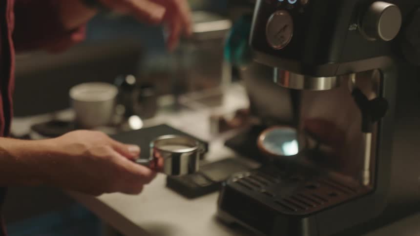 A person preparing coffee in a cappuccino machine