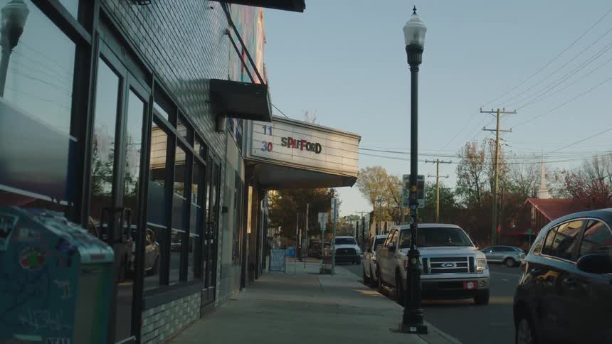 Cars parked in front of stores in a suburban neighborhood