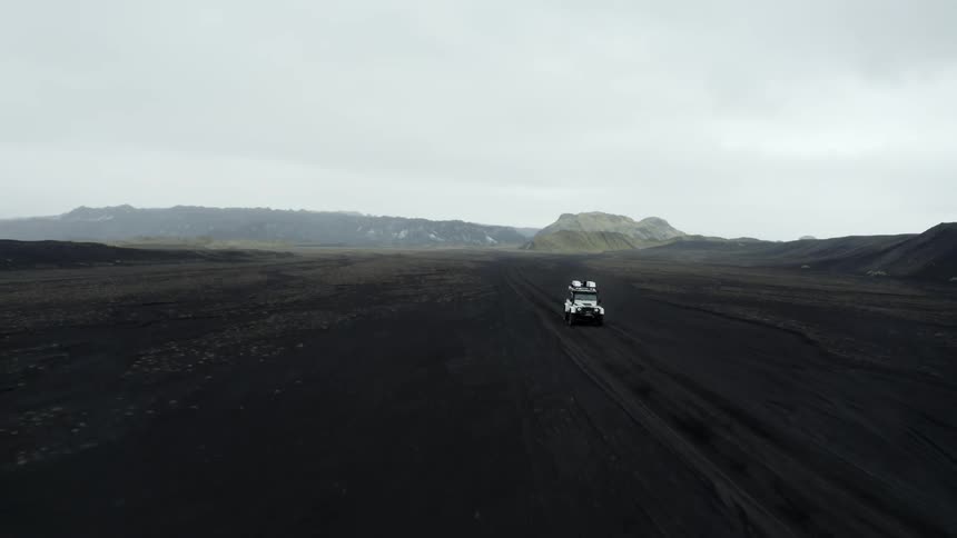 A car driving through a flat outdoor landscape