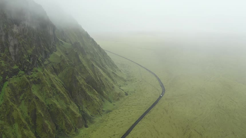 Aerial of a car on the desert road in the mountains landscape