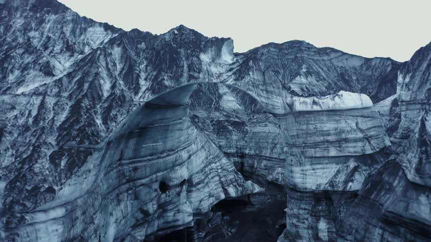 A mountain range of canyons with a frozen river during the day