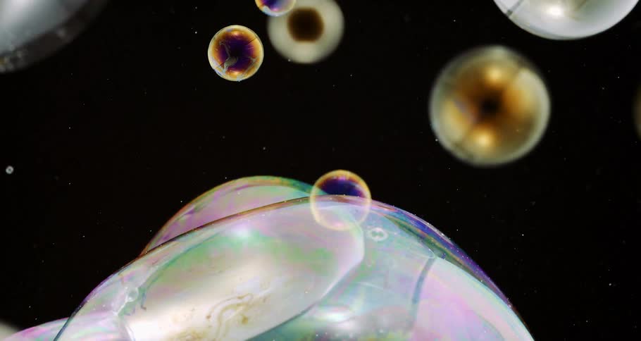 Extreme closeup of colorful water bubbles falling in slow motion