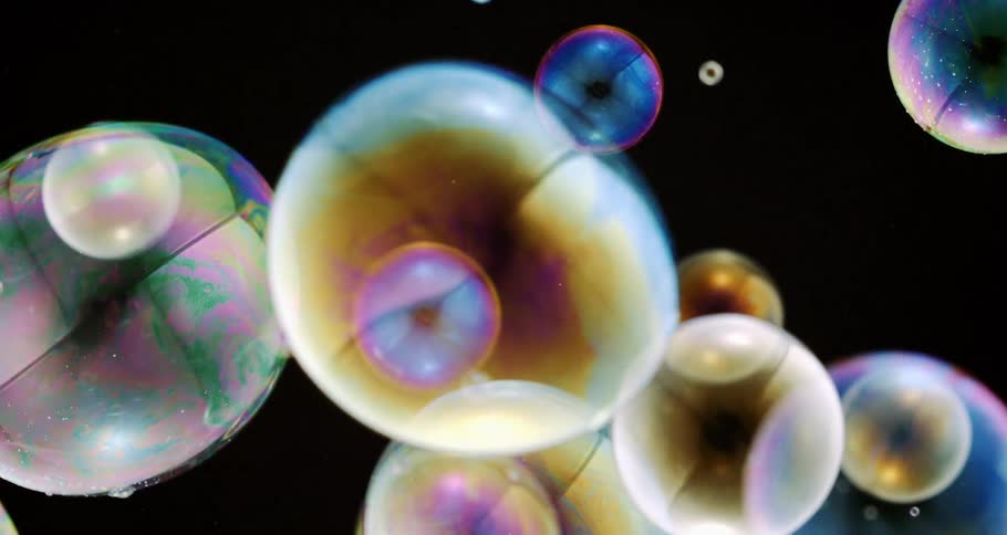 Colored ringed orbs jiggle as they float and move in the darkness