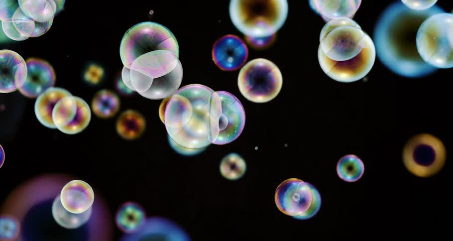 Colorful bubbles falling in slow motion on a black background