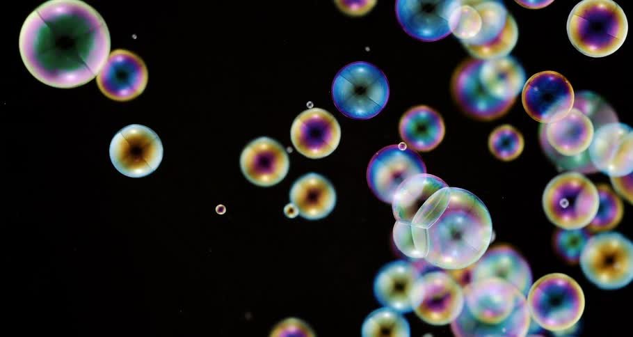 Translucent colored ringed orbs jiggle as the float in the darkness