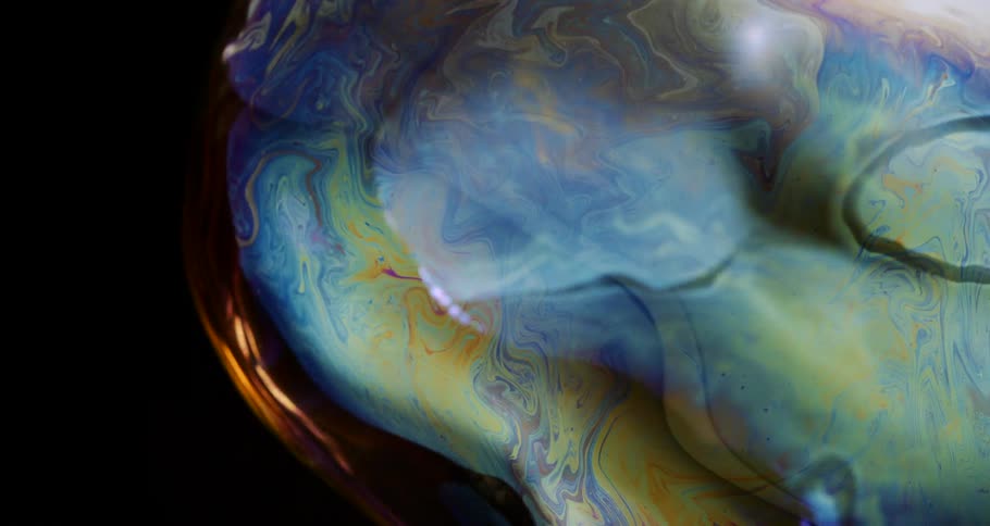 Colored soap bubble in extreme closeup moving in slow motion