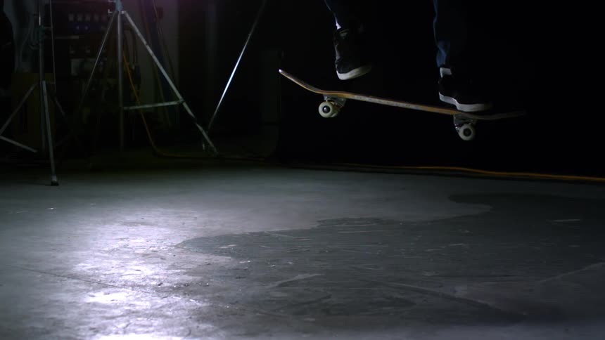 Closeup on the legs of a person skateboarding in slow motion