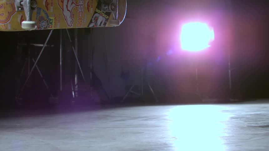 Skateboarder performs trick on stage