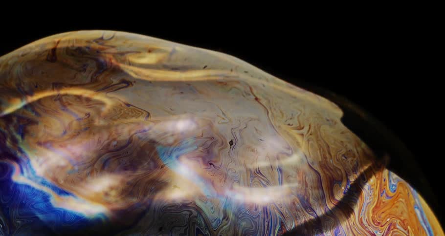 Extreme closeup of a colorful water bubble in slow motion