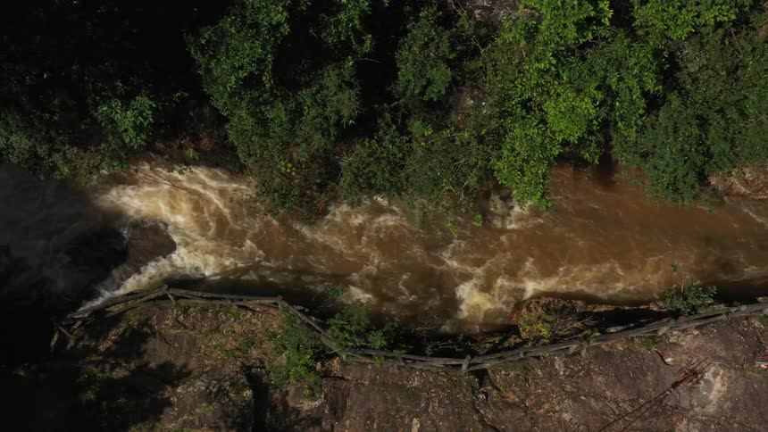 View from above to a flowing river and surrounding forest and rocks