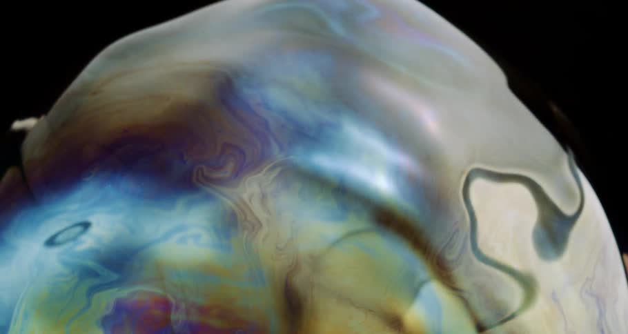 Microscopic view of a colorful soap bubble in slow motion