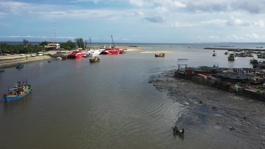 Aerial of a beach with fishing boats anchored at the shore