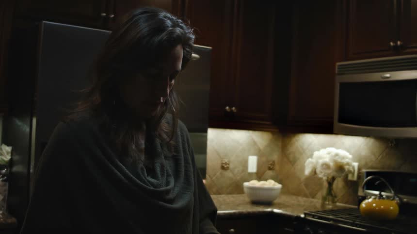 A woman stands in a kitchen