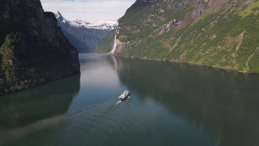 Aerial view of a ferry moving on a lake in the mountains