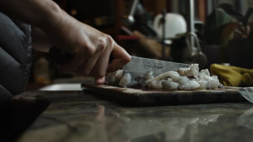 A man chops something on a cutting board